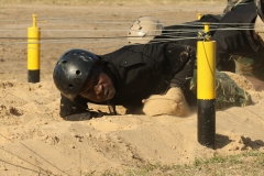 A Guyanese comando crawls beneath wires during a Fuerzas Comando obstacle course July 24, 2017, in Vista Alegre, Paraguay. This competition increases training knowledge and furthers interoperability between countries in the Western Hemisphere. (U.S. Army photo by Sgt. Joanna Bradshaw/Released)